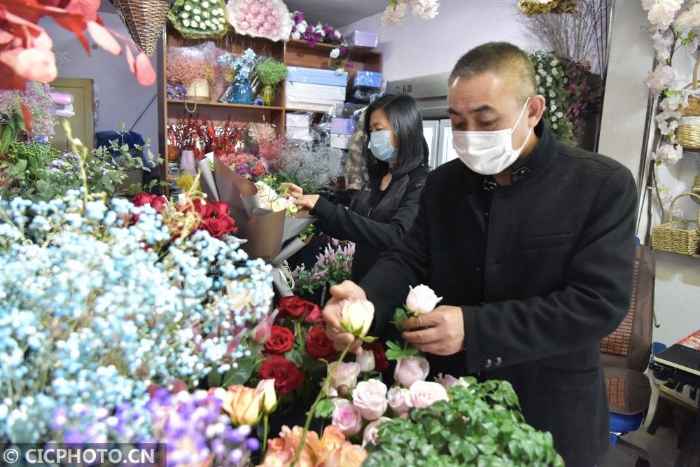 河北省邯郸市广平县城区一家花店内店员正在包装客人预定的鲜花